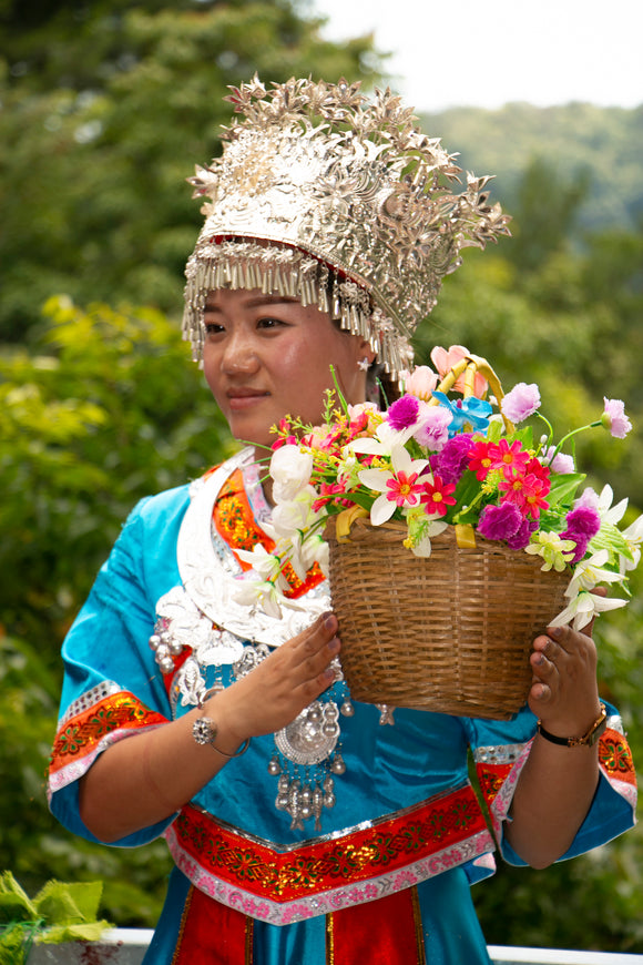 Chinese lady carying a flower basket in Yunnan Province